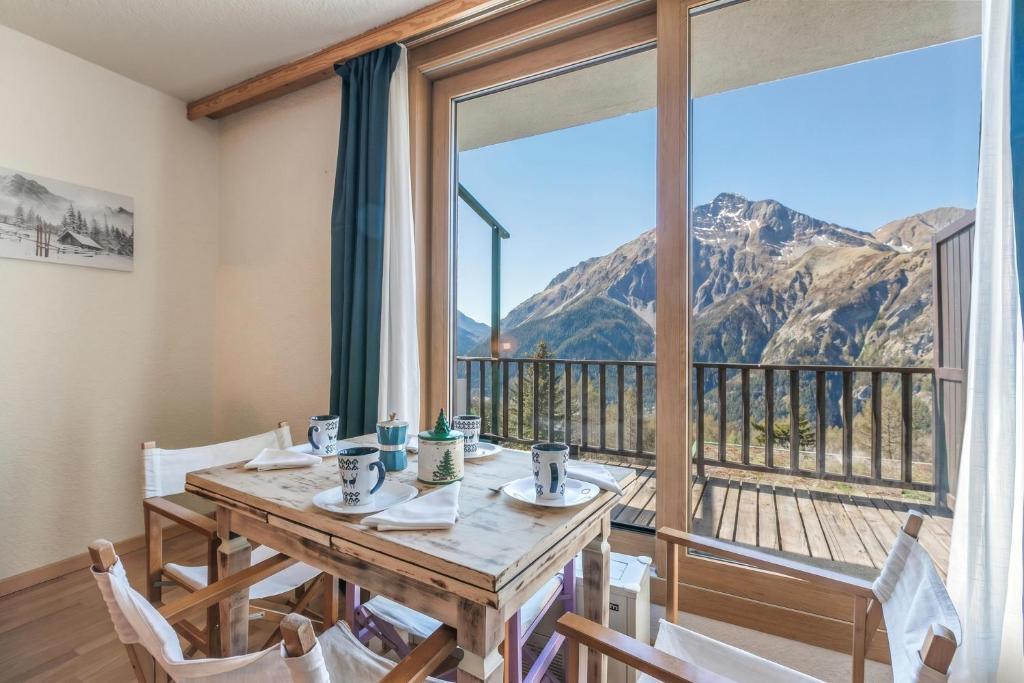 a dining room with a table and a large window at Studio Sansi 34 - Happy Rentals in Cesana Torinese