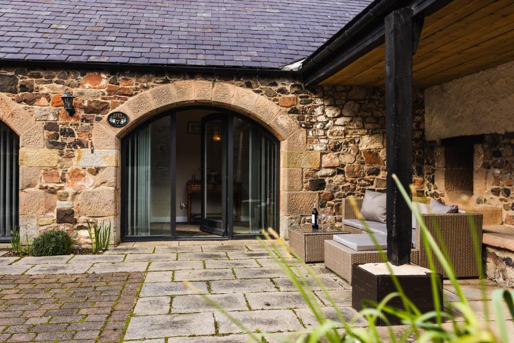 an entry to a stone building with an archway at Fern Cottage in Wooler