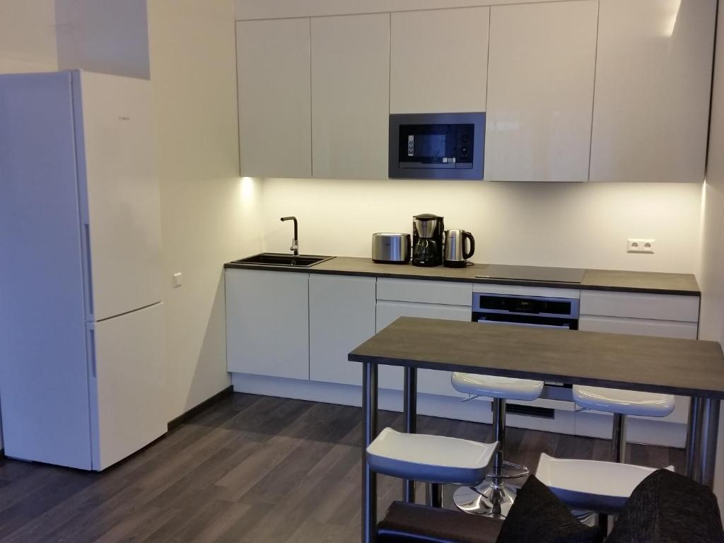 a kitchen with white cabinets and a table and chairs at Tehvandi Ski Apartment in Otepää