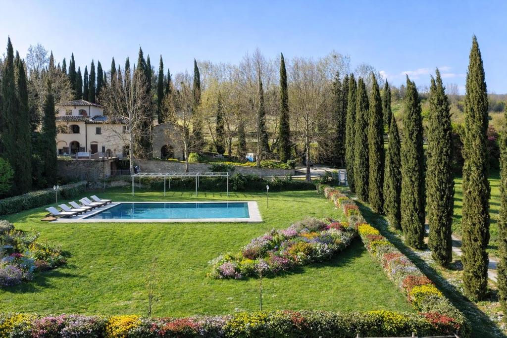 a garden with a swimming pool and trees at Villa With Pool, Gym, Pond And Panoramic Views in Laterina