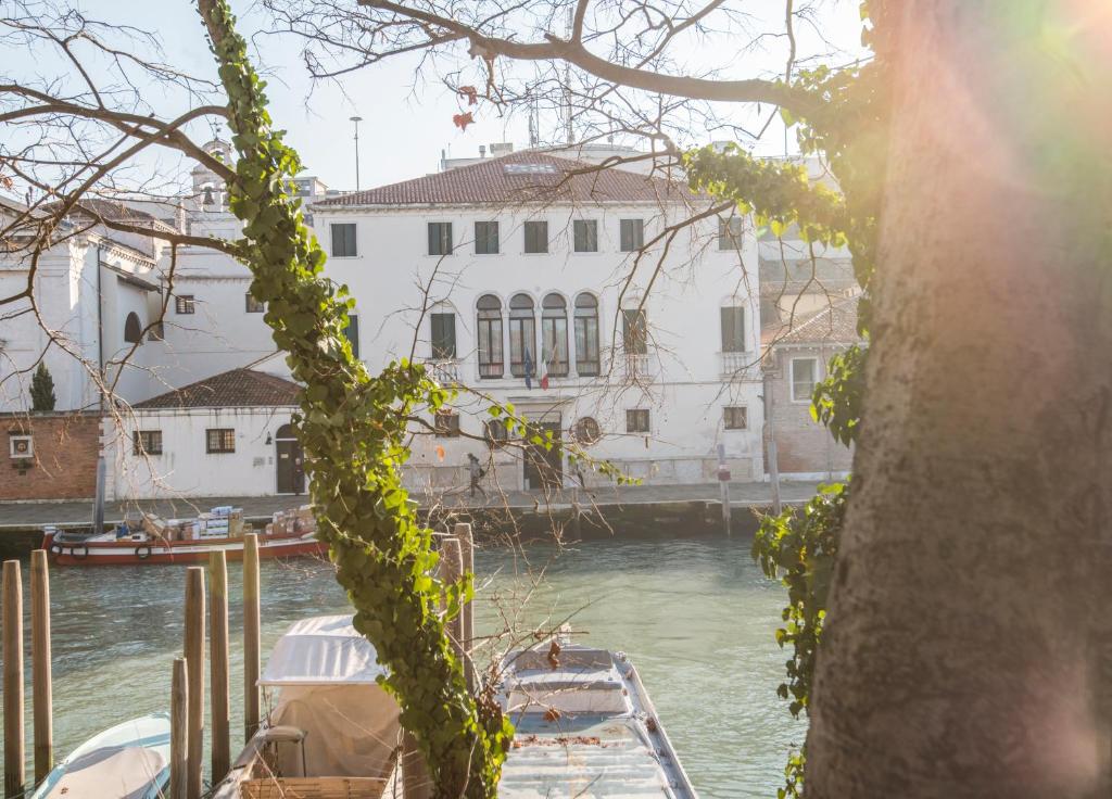 um barco está ancorado num rio com edifícios em Casa Sant'Andrea em Veneza