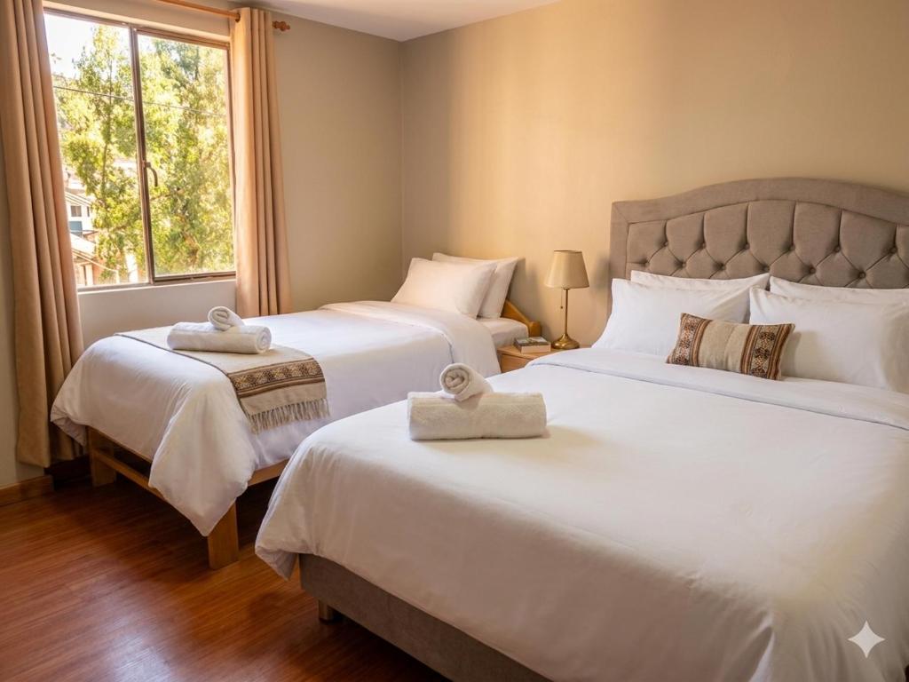 a bedroom with two beds with towels on them at Llama House Cusco in Cusco