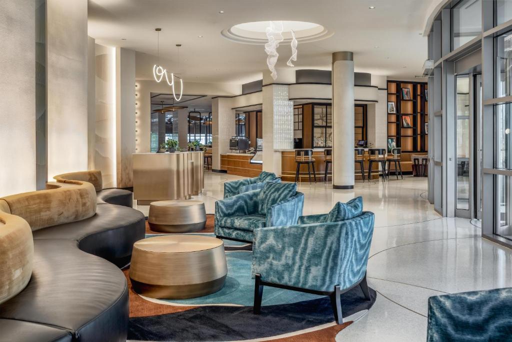 a lobby with couches and chairs and a table at Hyatt Centric Chicago Ohare in Rosemont