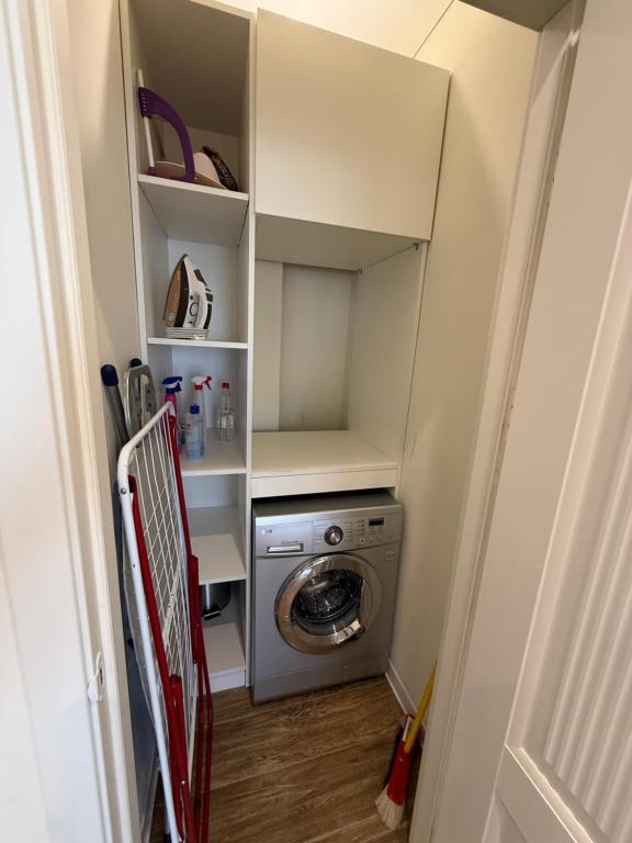 a small laundry room with a washer and dryer at Apartamentul white Arena in Chişinău