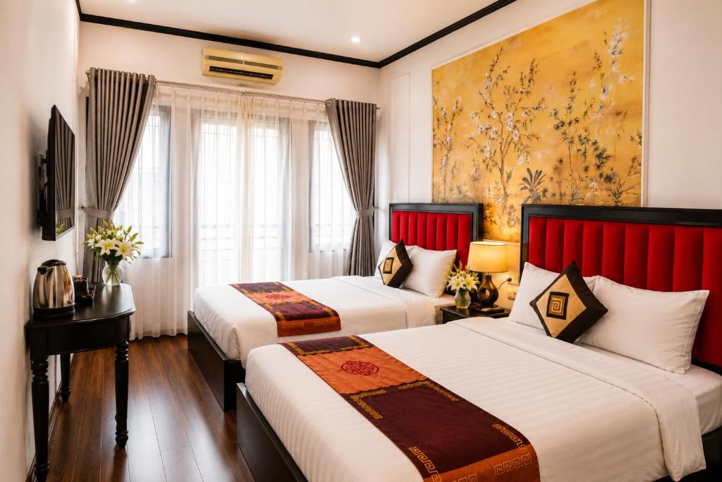 two beds in a hotel room with red headboards at Hanoi Sena Hotel & Travel in Hanoi