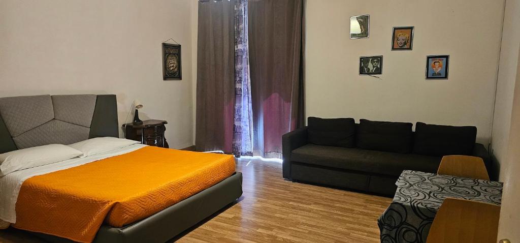 ein Schlafzimmer mit einem Bett und einer Couch in der Unterkunft Affittacamere Nilo in Neapel