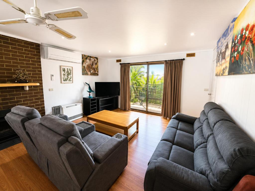 a living room with two couches and a tv at Apollo bay Holiday House in Apollo Bay