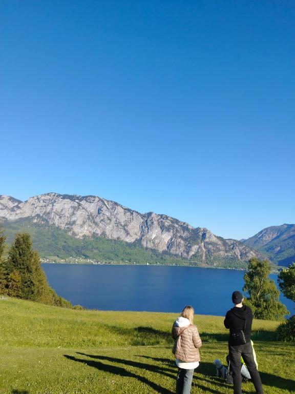 a group of people walking in a field near a lake at MEGA WEEKEND Apartment in Salzkammergut Nähe Attersee Traunsee Gmunden Bergen in Attnang-Puchheim