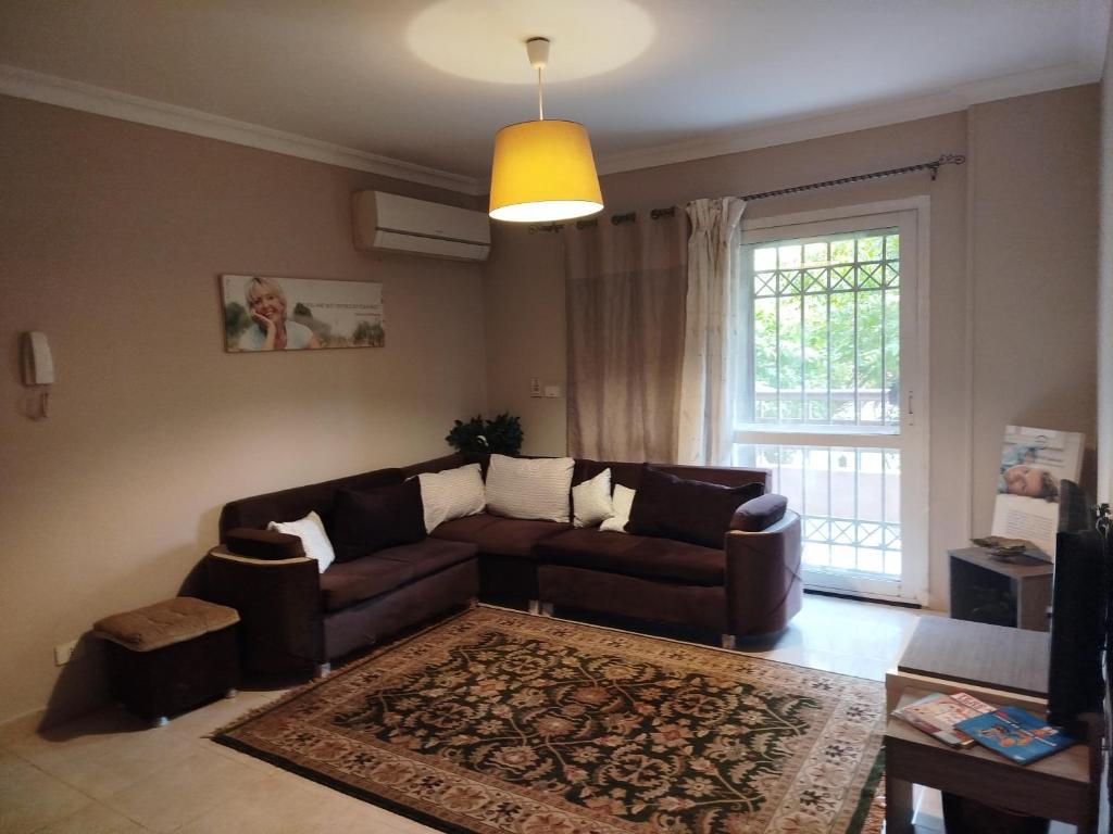 a living room with a couch and a window at Madinaty Summer cottage in Cairo