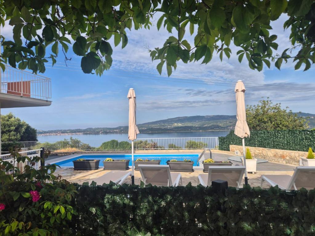a view of a pool with umbrellas and chairs at Casa di Pietro 2 in Fársa