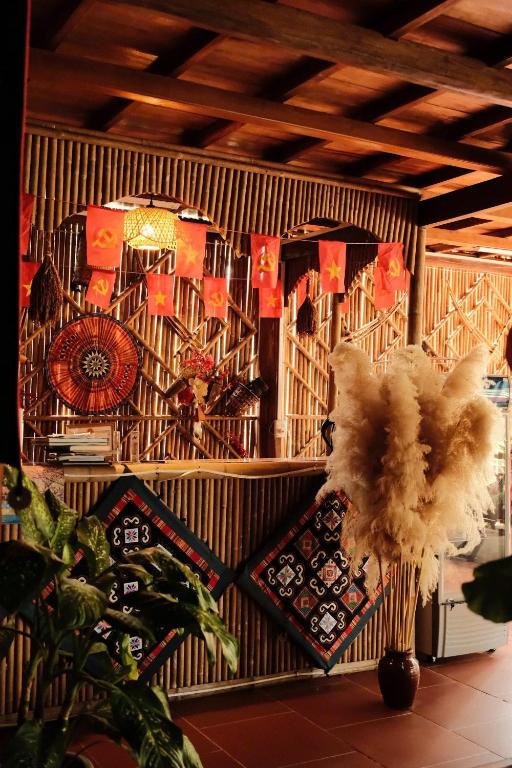 a room with a wall with chinese flags and flowers at NorthWest Home in Mai Châu