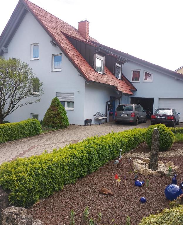a white house with cars parked in a driveway at Ferienwohnung Kemmerth in Ebermannstadt