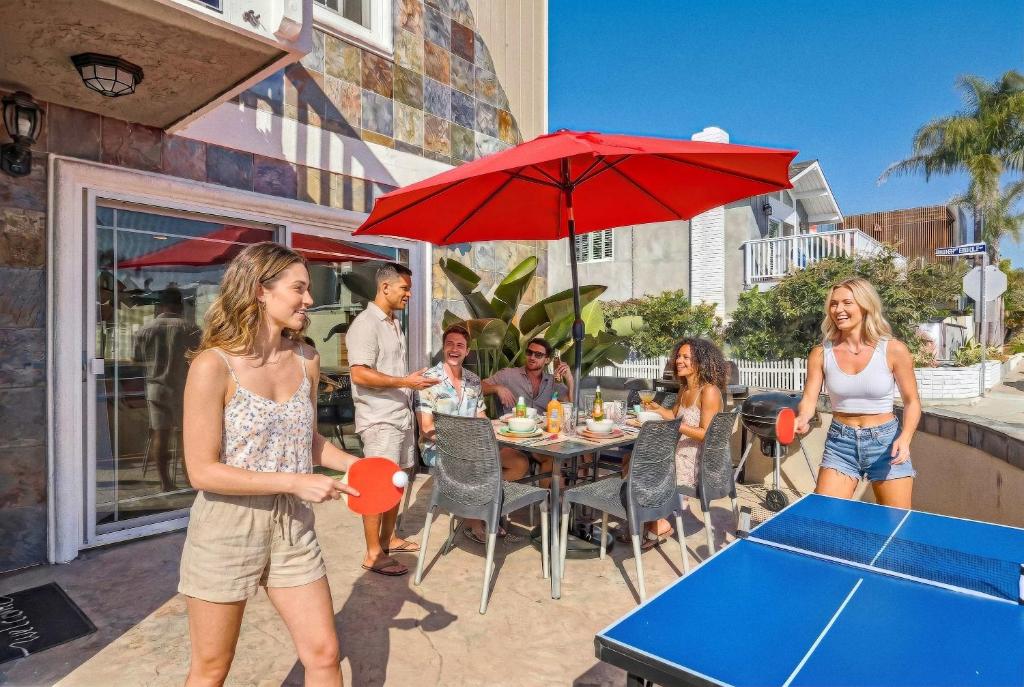 a group of people playing a game of ping pong at Awesome 3BR 2BTH 1 Block To Beach C2 in Newport Beach