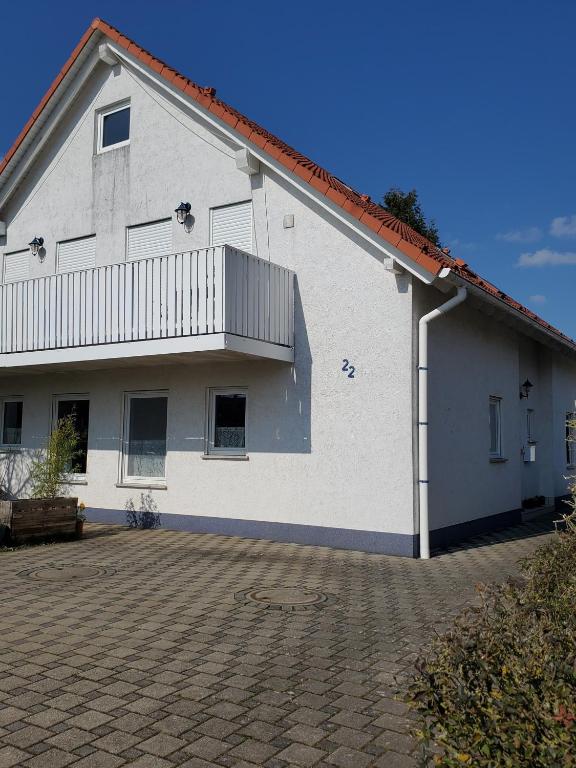 a white building with a balcony on the side of it at Siggis-Ferienwohnung in Bad Wildungen