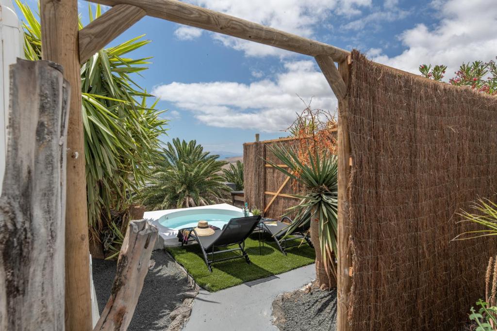 a backyard with a pool and a chair and a fence at Suite Junior Amanecer in Mácher