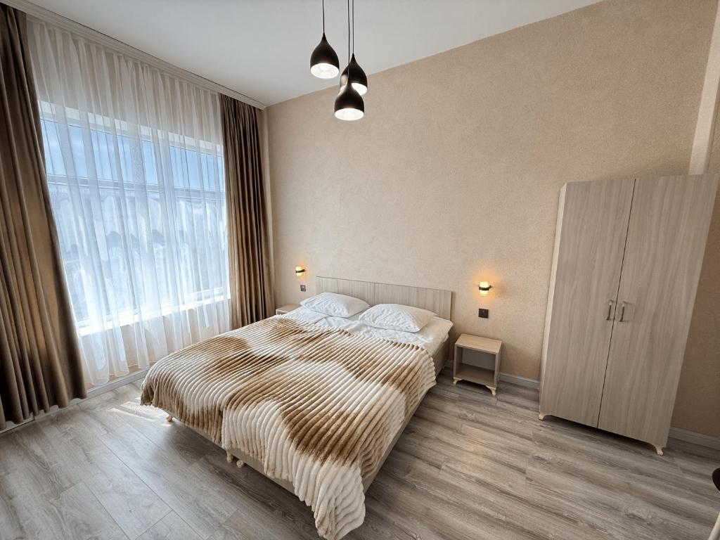 a bedroom with a large bed and a large window at Miva in Qusar