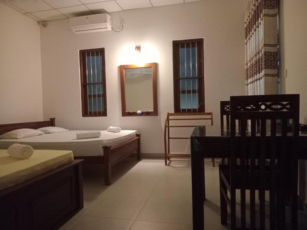 a room with two beds and a mirror at Mihinsa Guest in Kosgoda