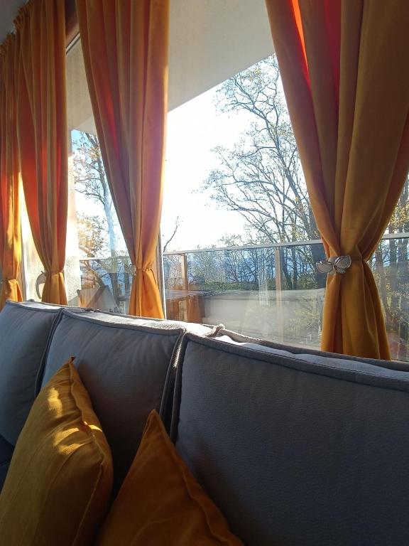a couch in front of a window with curtains at ВЕСЕЛА ВАКАНЦИЯ Китен in Kiten
