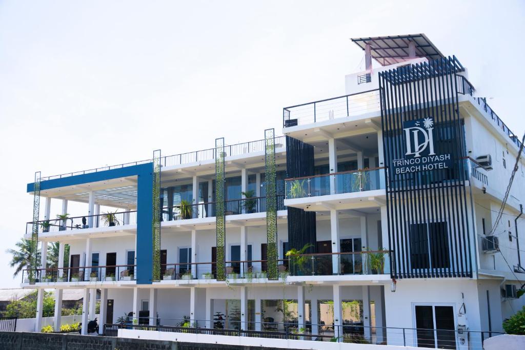 a white building with a sign on it at Trinco Diyash Beach Hotel in Trincomalee