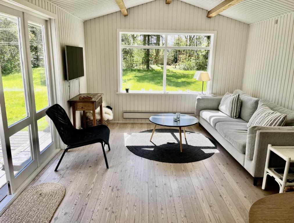a living room with a couch and a table at Charming Beach Cottage In Gilleleje in Gilleleje