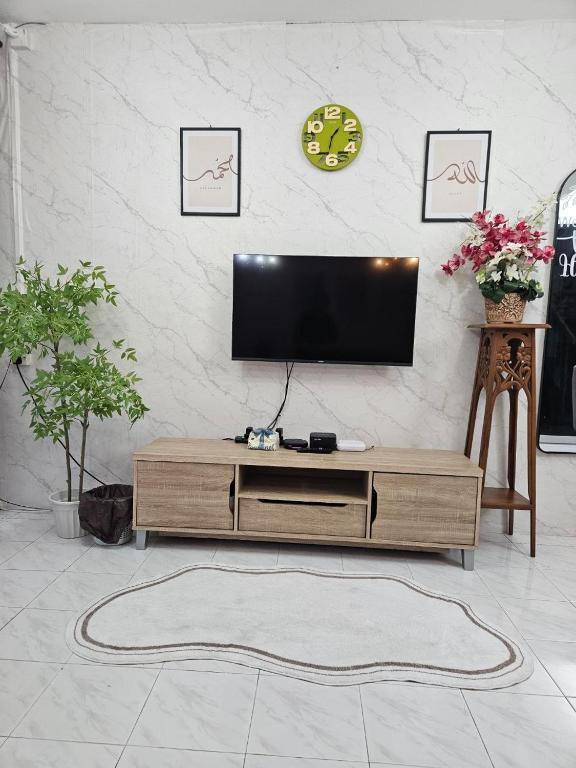 a living room with a flat screen tv on a wall at Homestay Iliana in Kangar