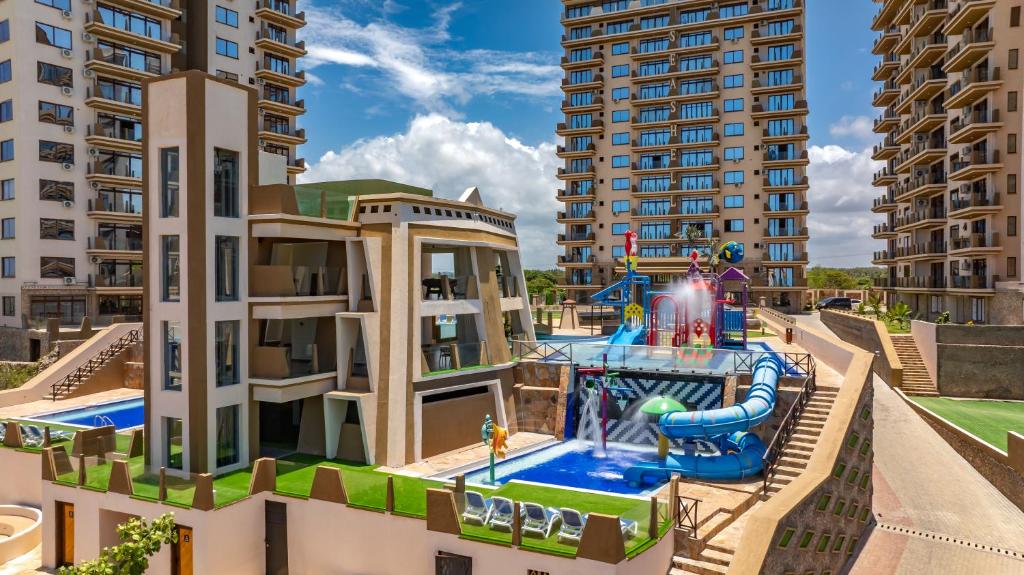 an apartment complex with a water park in front of buildings at Tulip Residences Vipingo Mombasa in Mombasa