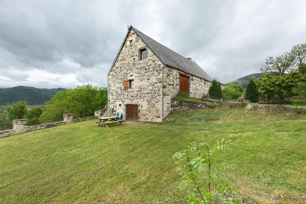 an old stone building with a bench in a field at Gîte Le Panorama in Rentières