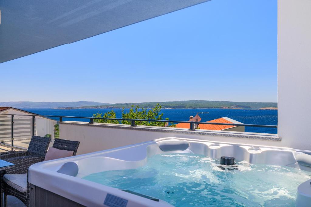 a hot tub on a balcony with a view of the water at Schmidt veliki in Dramalj