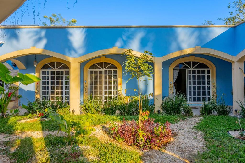 a blue house with windows and a yard at Amplia Habitación Doble 7, Alberca, Gym y Terraza in Mérida
