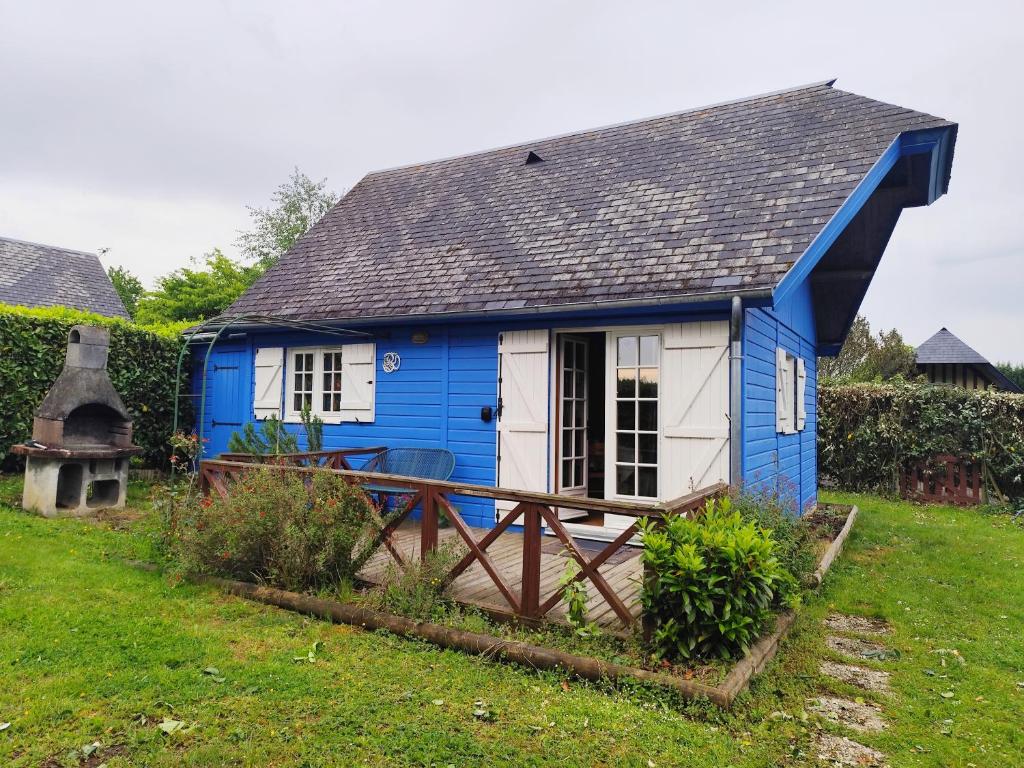 a blue and white house in a yard at La maison bleue in Saint-André-dʼHébertot