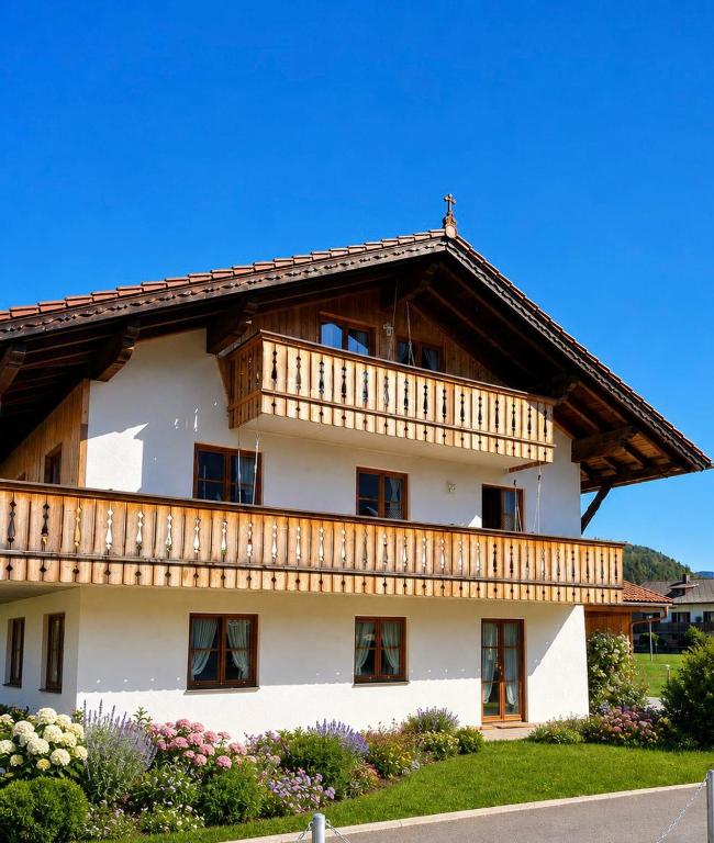 a large white building with a wooden balcony at Haus Rosamirl Ferienwohnung in Wallgau