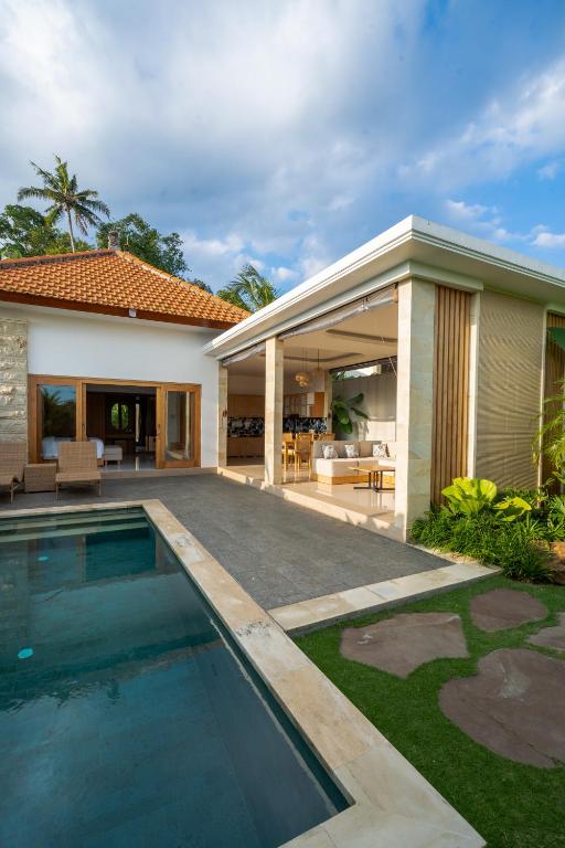 a house with a swimming pool next to a house at Suralaya Villas in Ubud