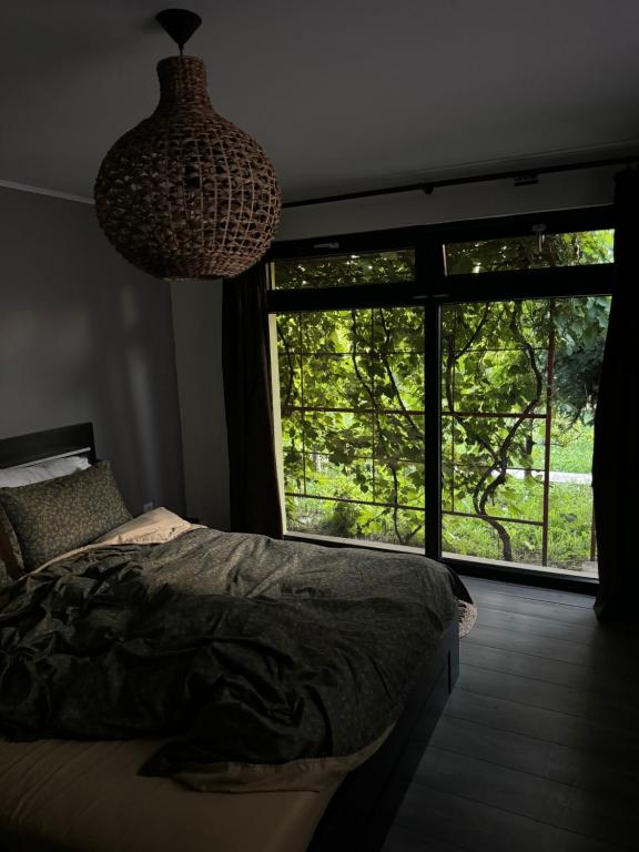 ein Schlafzimmer mit einem Bett und einem großen Fenster in der Unterkunft O Casǎ in 23 August