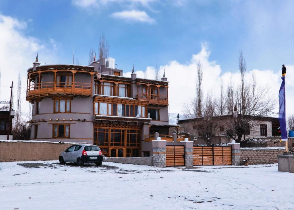 a building with a car parked in front of it at Dakpa House Ladakh in Ranbirpura