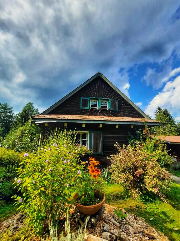 a small house with flowers in front of it at Chalupa Něža in Petrovice