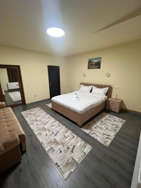 a bedroom with a large bed and two rugs at Apartamentele Liliacul in Sighetu Marmaţiei