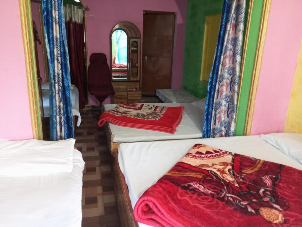 a group of beds in a room at Hotel shiva in Sar