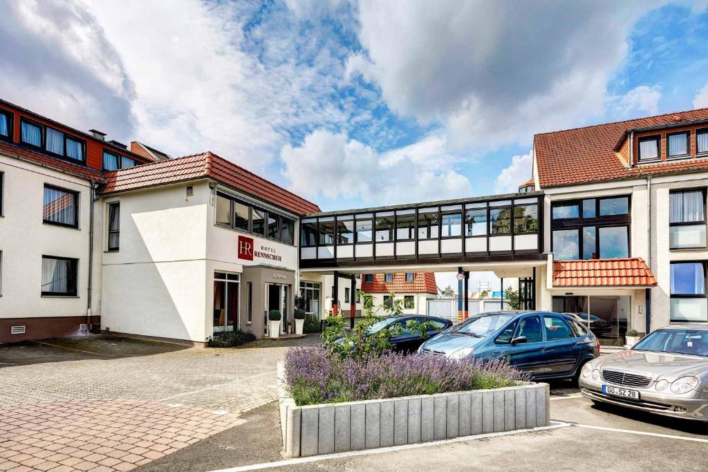 een gebouw met auto's geparkeerd op een parkeerplaats bij Hotel Rennschuh in Göttingen