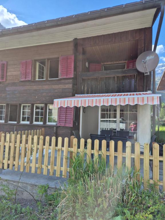 a wooden house with a fence in front of it at Nenis Hüsli in Diesbach
