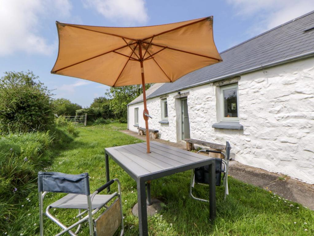 an umbrella sitting on a table in front of a house at Rhos Y Clegyrn in Goodwick