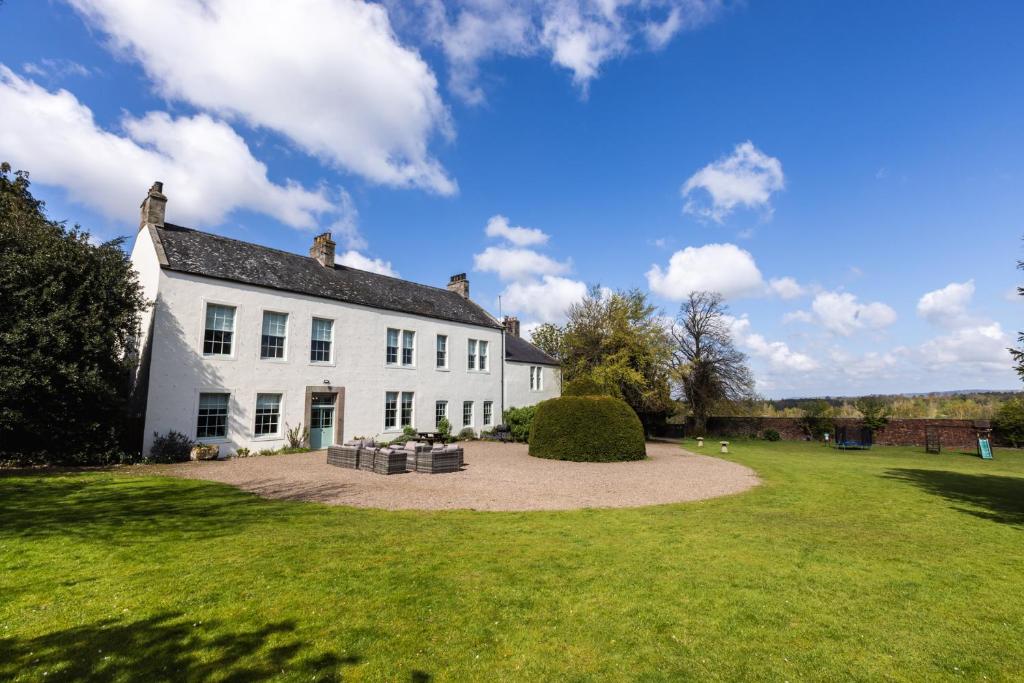 a large white house with a large yard at Cheviot Manor in Wooler