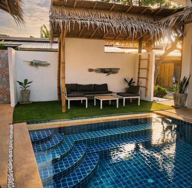 a villa with a swimming pool and a house at jungle pad accomodation in Rawai Beach