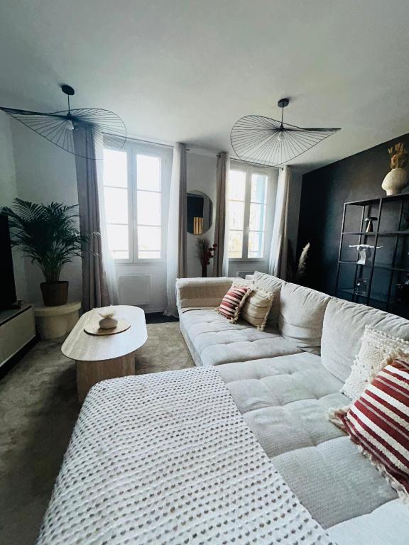 a living room with a white couch and a table at Downtown High Standing Duplex - "CENTRUM" in Épernay