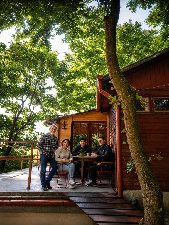 a group of people sitting at a table on the porch of a cabin at Peace House in Esztergom