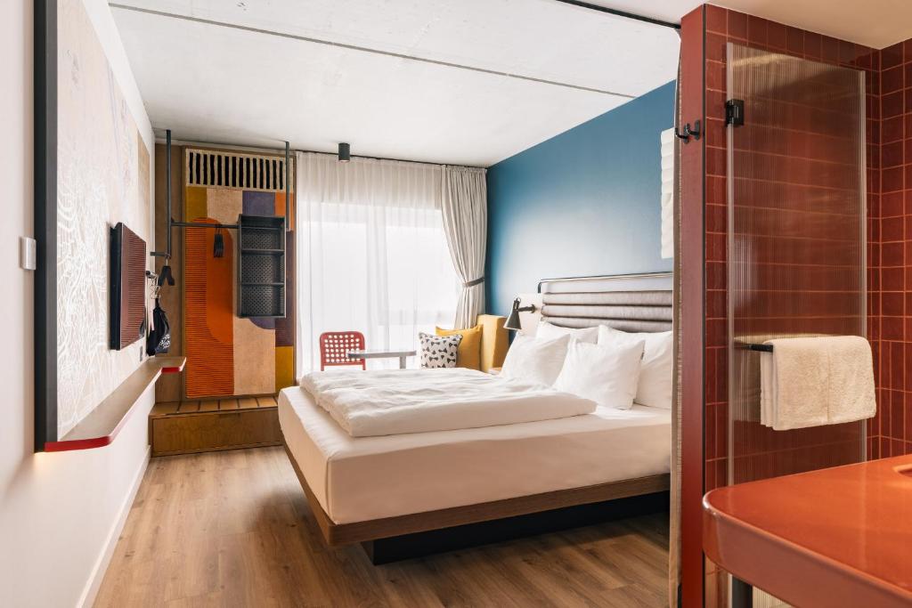 a hotel room with a bed and a bathroom at Hotel Schani Naschmarkt - opening September 2026 in Vienna