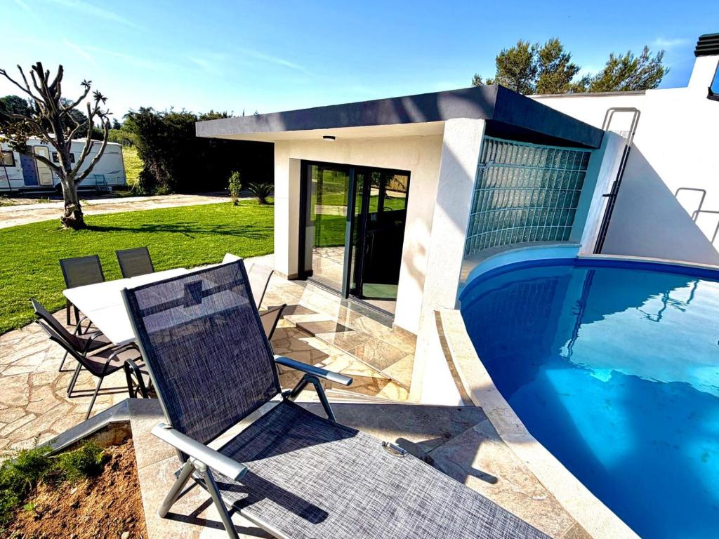 a swimming pool with a chair next to a house at Villa Escaldes in Montroig