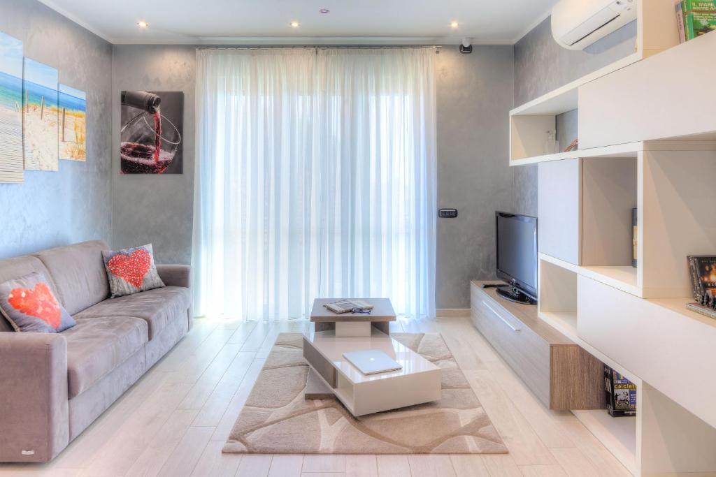 Una sala de estar con un sofá y un televisor. en Casa Kisso, en Diano Marina