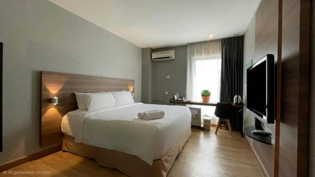 a hotel room with a bed and a television at The Leverage Business Hotel - Rawang in Rawang