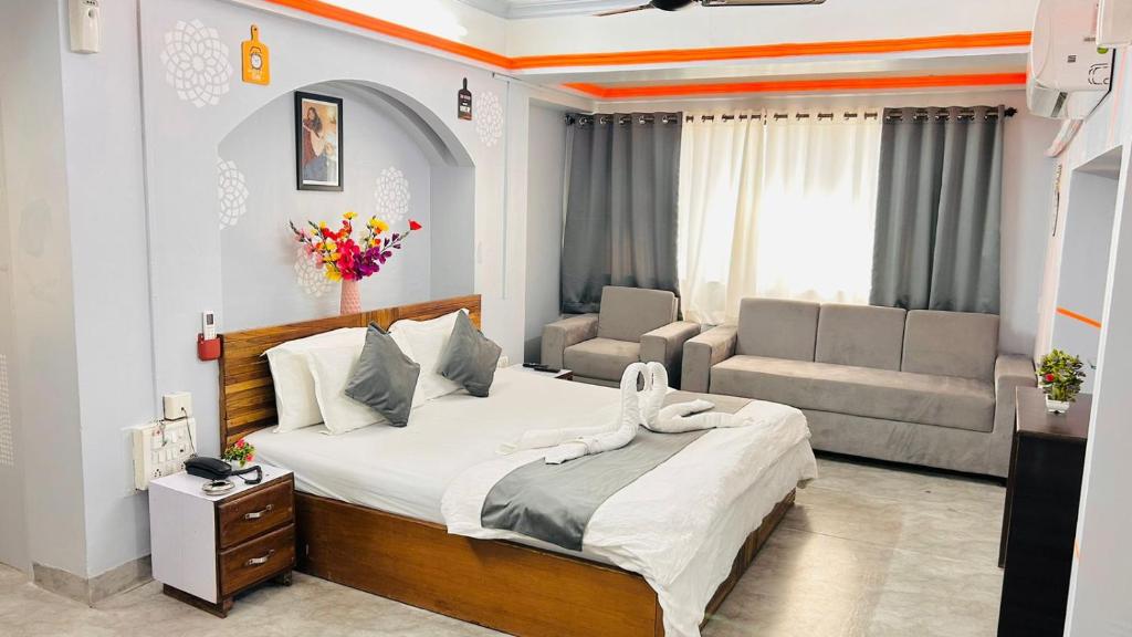 a bedroom with a large bed and a couch at Kalpataru Hometel in Mumbai