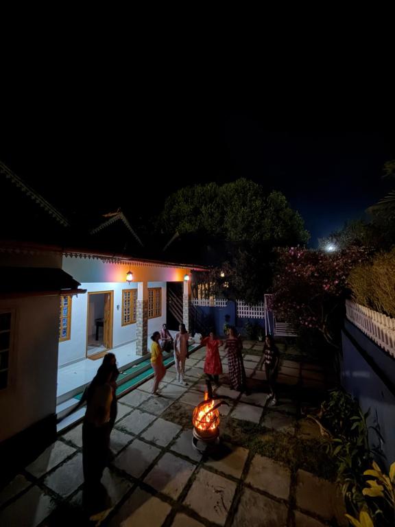 a group of people walking outside a house at night at Wiztearia in Ambalavayal
